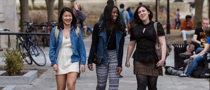 three students walking across campus